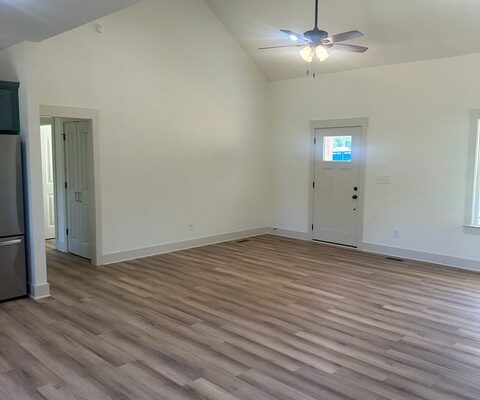 Open living area with vaulted ceiling and LVP flooring in Liberty Road home