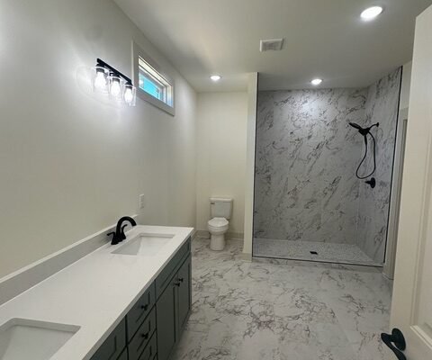 Primary bathroom with double vanity and large tiled shower in Charlotte, TN home