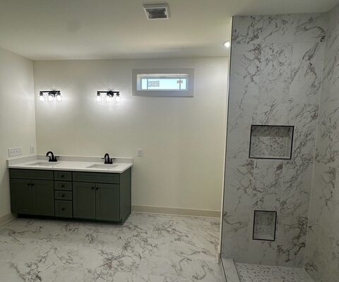 Primary bathroom with double vanity, quartz countertop, tile floor, and walk-in shower